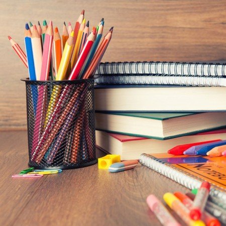 A pencil pot and books on a table. 